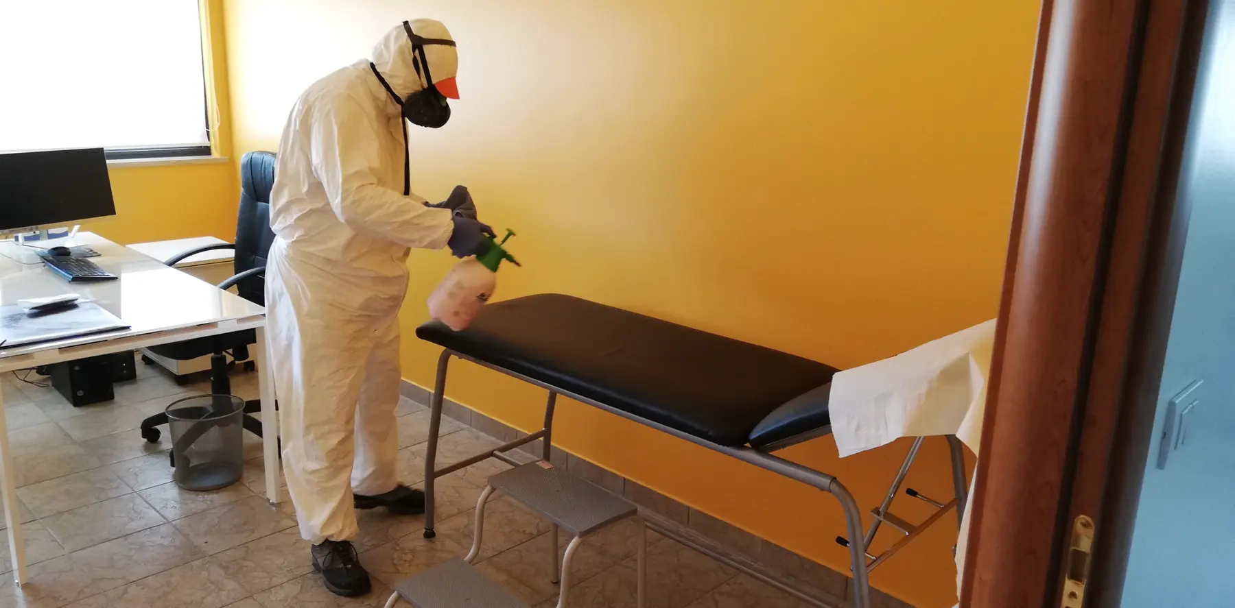 Tecnico L'Aurora durante la sanificazione di un lettino medico